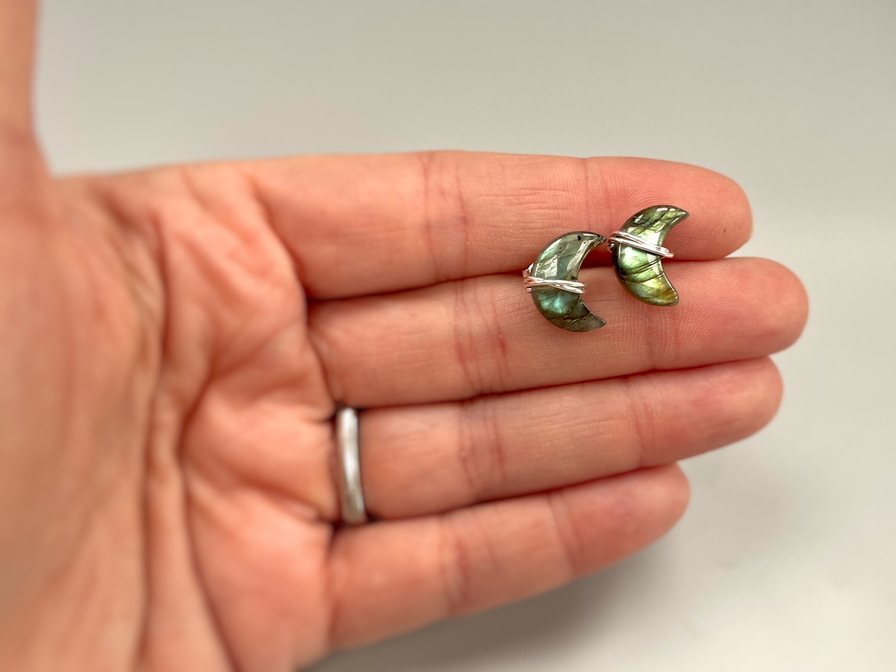 Sterling Silver Crescent Moon Labradorite Stud Earrings in hand ear for scale