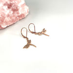 May include: A pair of rose gold dragonfly earrings with a delicate filigree design.