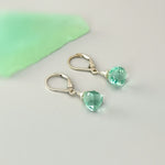 May include: A pair of silver dangle earrings with light green gemstone drops