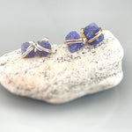 May include: Two pairs of earrings with purple gemstones wrapped in silver and gold wire.