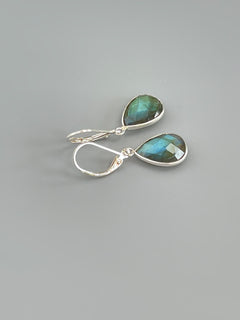 May include: A pair of silver dangle earrings with teardrop shaped green labradorite stones.
