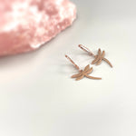 May include: Two rose gold dragonfly earrings with a hoop design