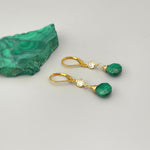 May include: Gold earrings with green malachite stones and clear cubic zirconia accents.