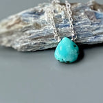 May include: A turquoise gemstone pendant necklace with a silver chain.