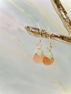 May include: A pair of silver earrings with light pink and light green gemstone beads