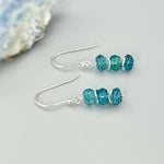May include: Silver dangle earrings with three blue green gemstone beads on each earring.