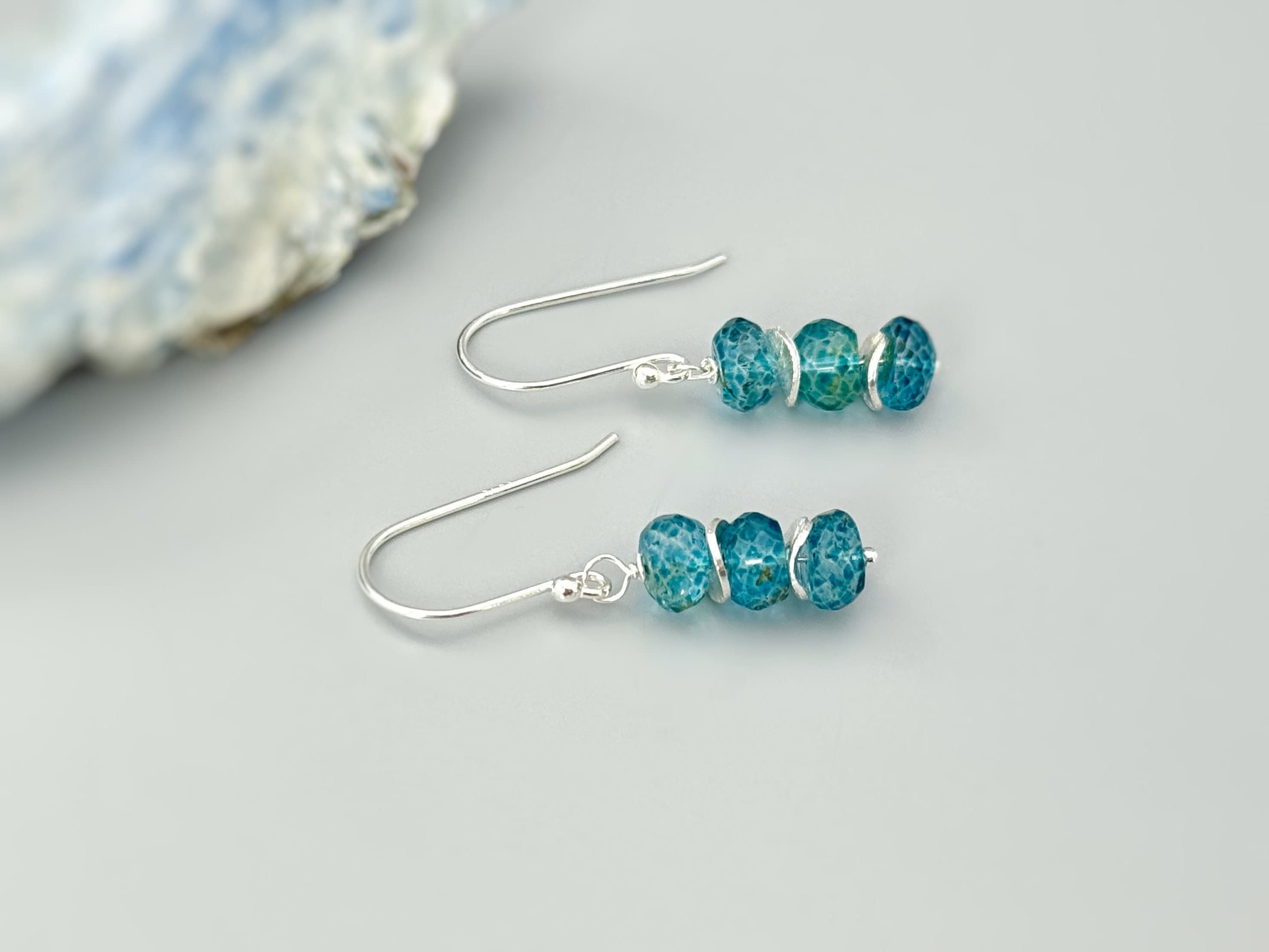May include: Silver dangle earrings with three blue green gemstone beads on each earring.
