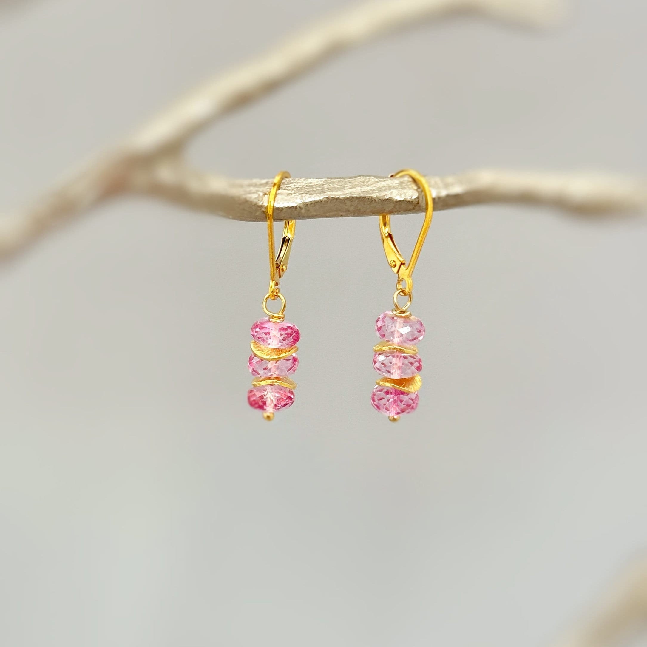 May include: Gold dangle earrings with three pink crystal beads on each earring.