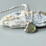 May include: A silver chain necklace with a green labradorite gemstone pendant