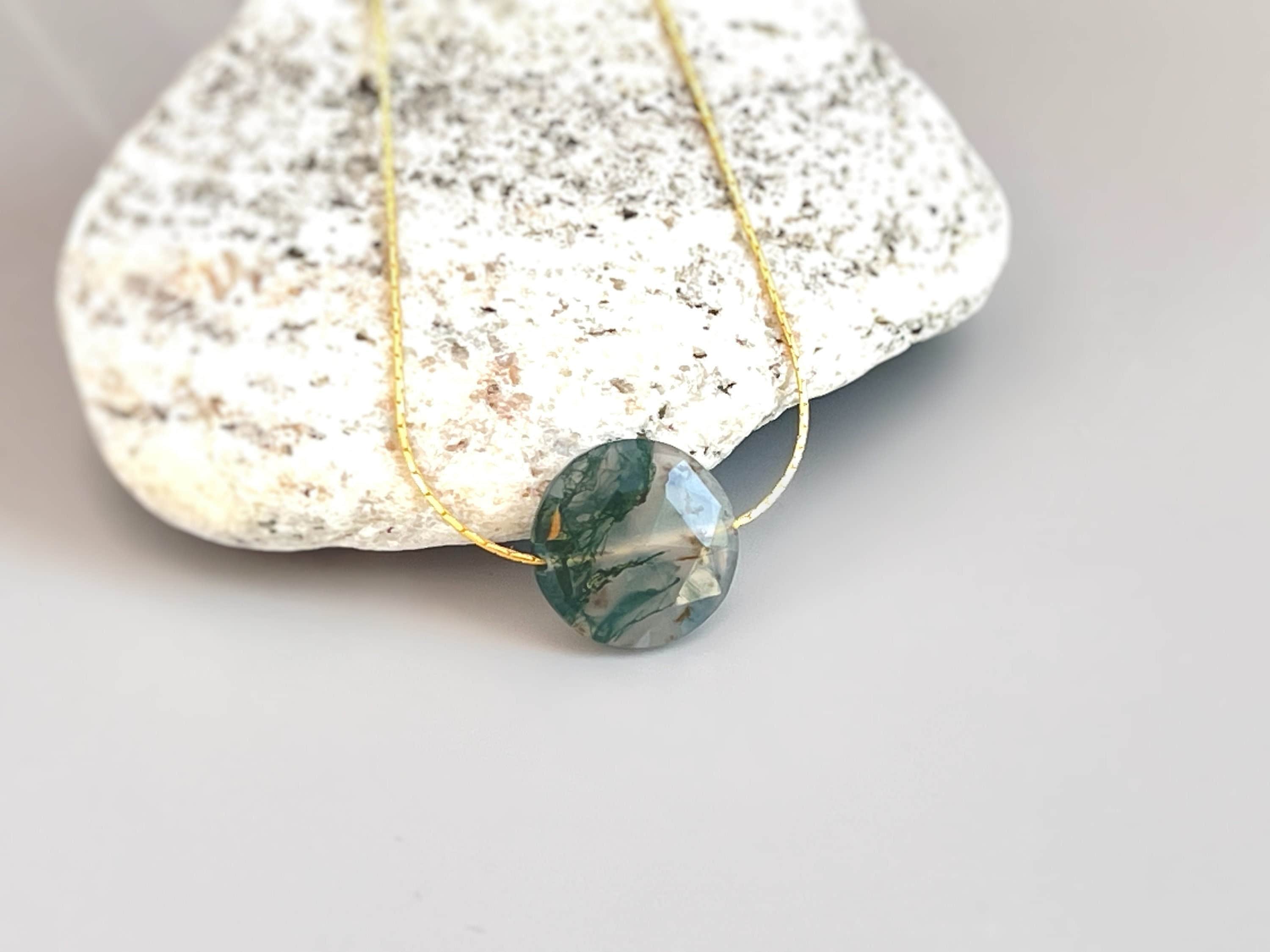 May include: A gold chain necklace with a green and white agate pendant
