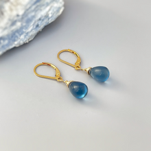 Load image into Gallery viewer, a pair of gold earrings with blue glass drops