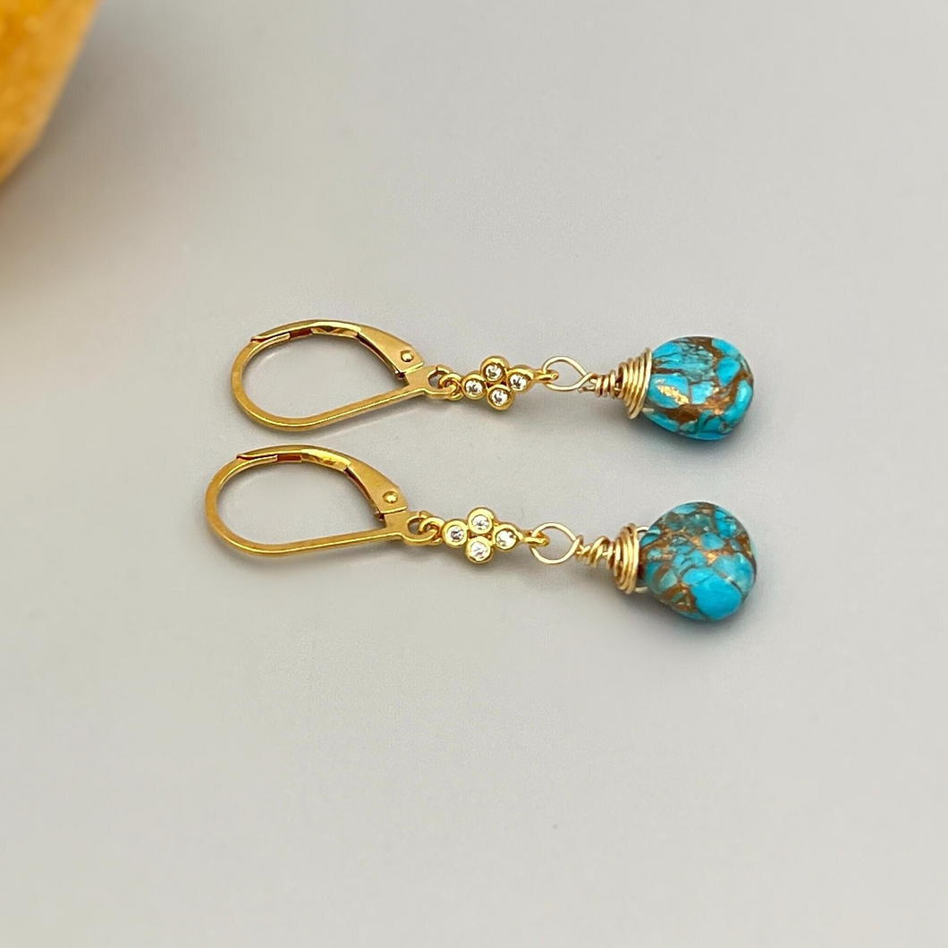 a pair of gold earrings with turquoise beads