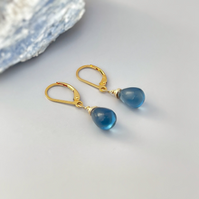 Load image into Gallery viewer, a pair of gold earrings with blue glass drops