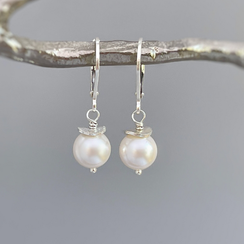 a pair of white pearls hanging from a branch