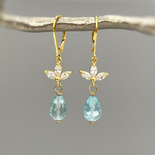 Load image into Gallery viewer, a pair of gold earrings with blue topazte and diamonds