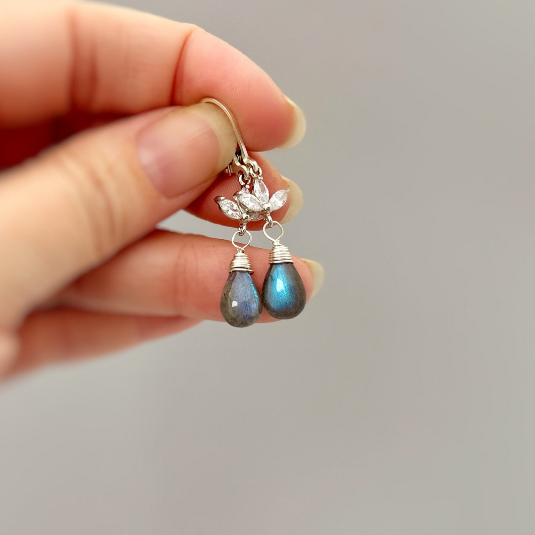 a person holding a pair of earrings in their hand